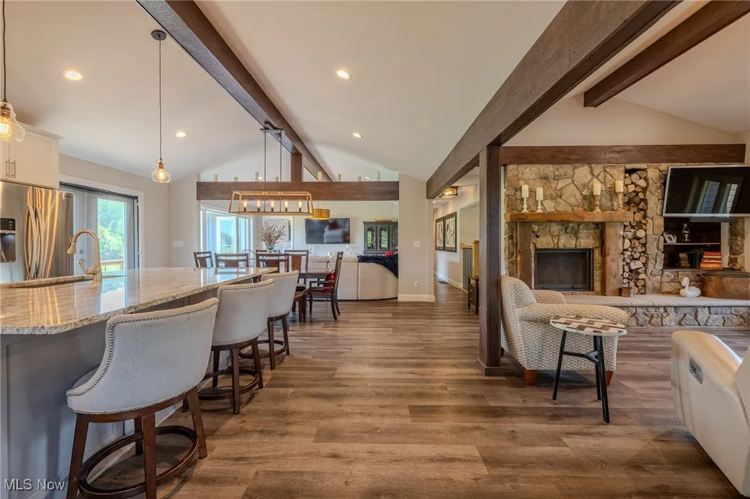 Living area with a fireplace, dark wood-type flooring, baseboards, and recessed lighting