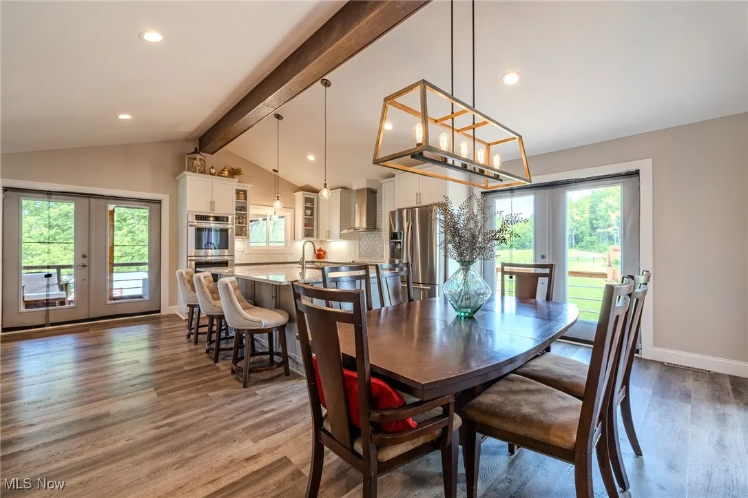 Dining room with french doors, wood finished floors, recessed lighting, and baseboards