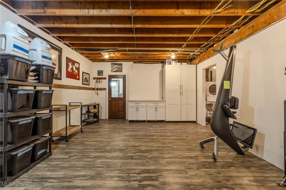 Unfinished below grade area featuring dark wood-type flooring