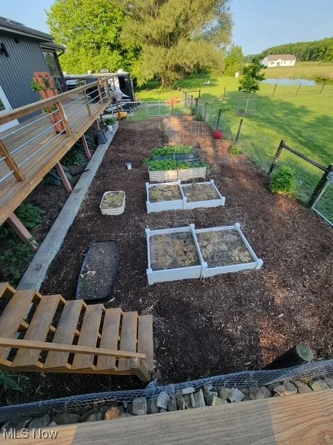 View of yard featuring a garden and a water view