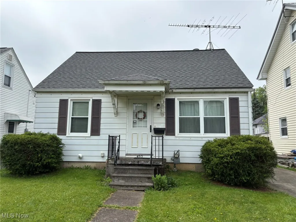 Bungalow-style house featuring a front yard and a shingled roof