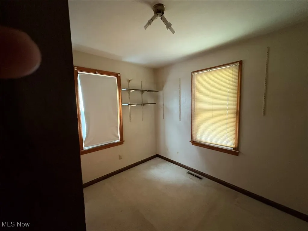 Spare room featuring carpet floors and baseboards