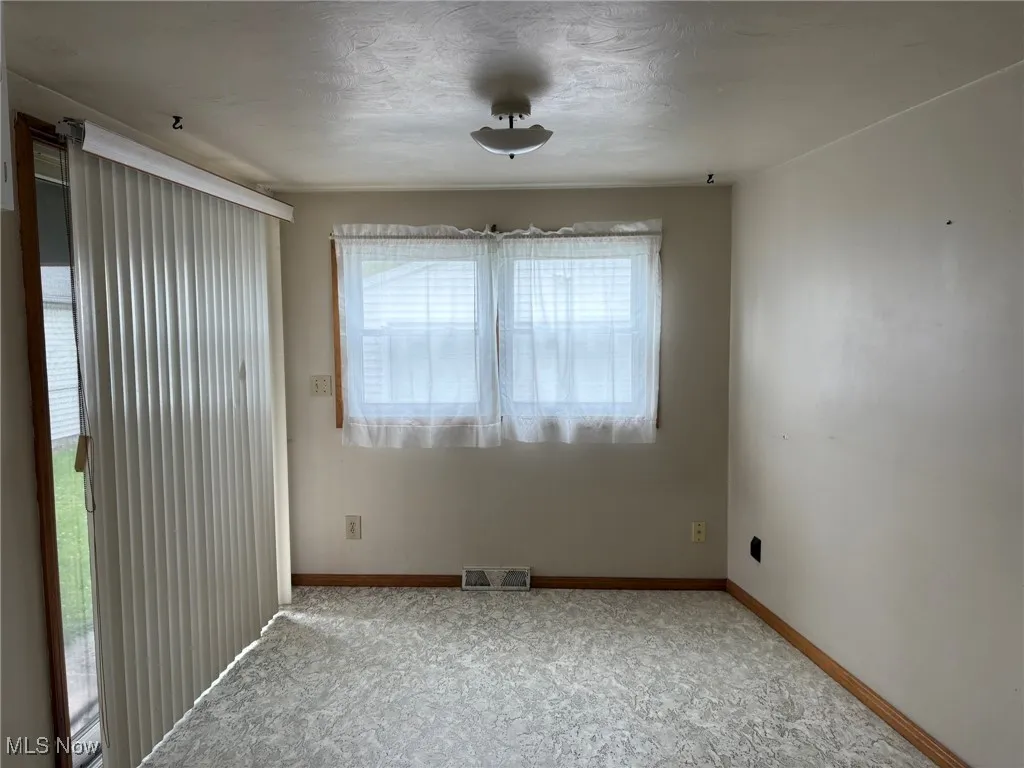 Unfurnished room with carpet and baseboards