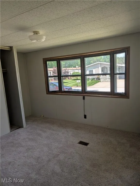 Unfurnished bedroom with multiple windows and carpet flooring