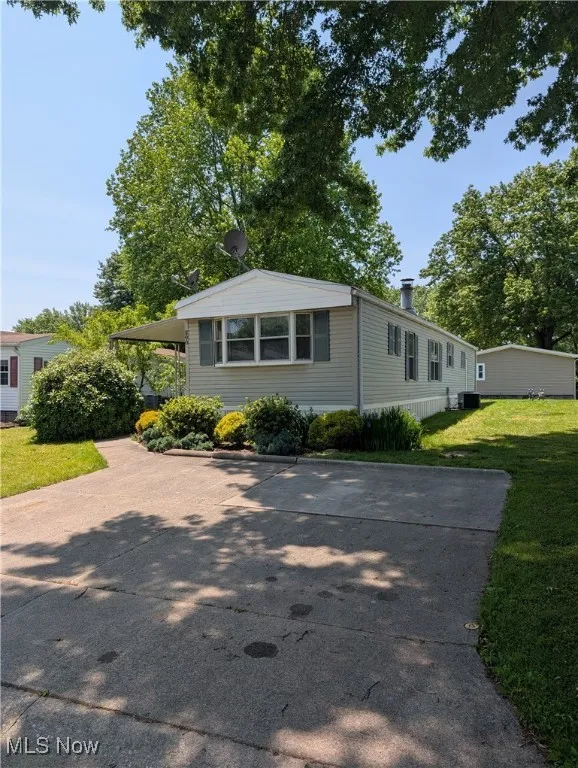 Manufactured / mobile home with a front yard and driveway