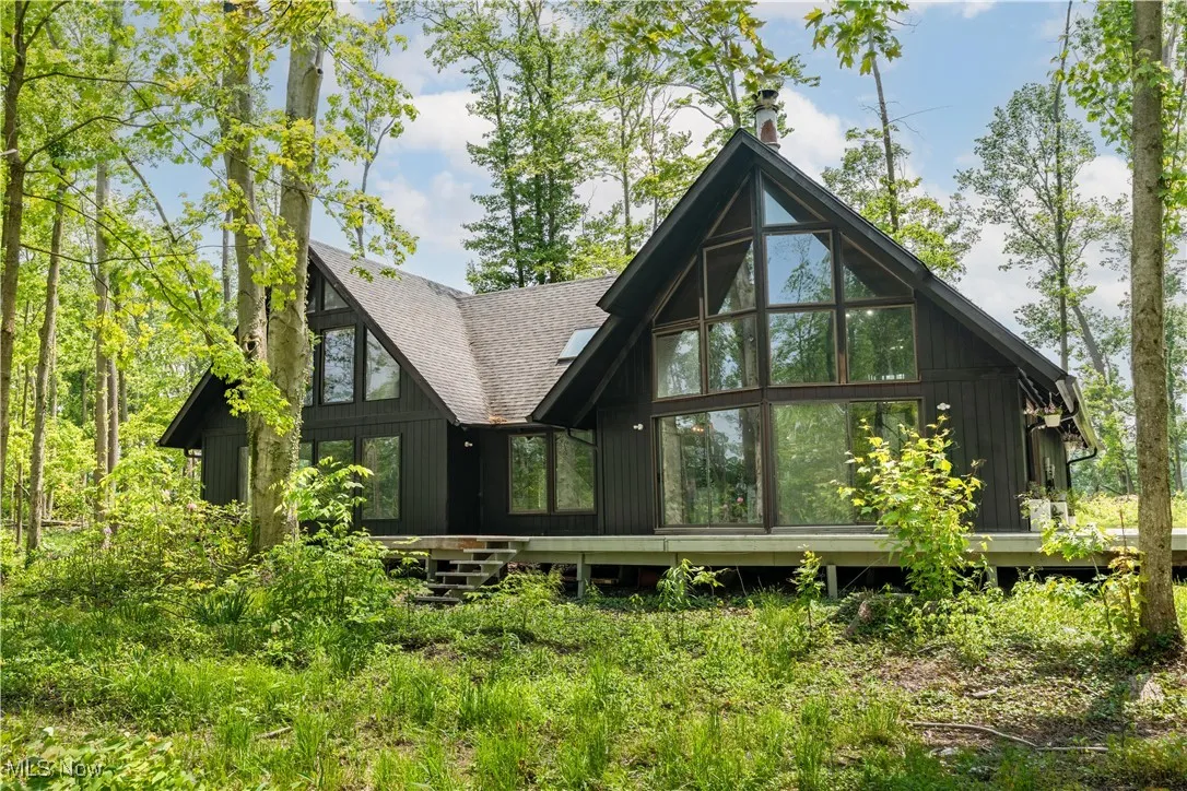 Rear view of house featuring roof with shingles