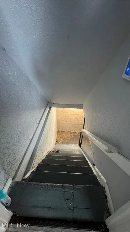 Stairs featuring a textured wall