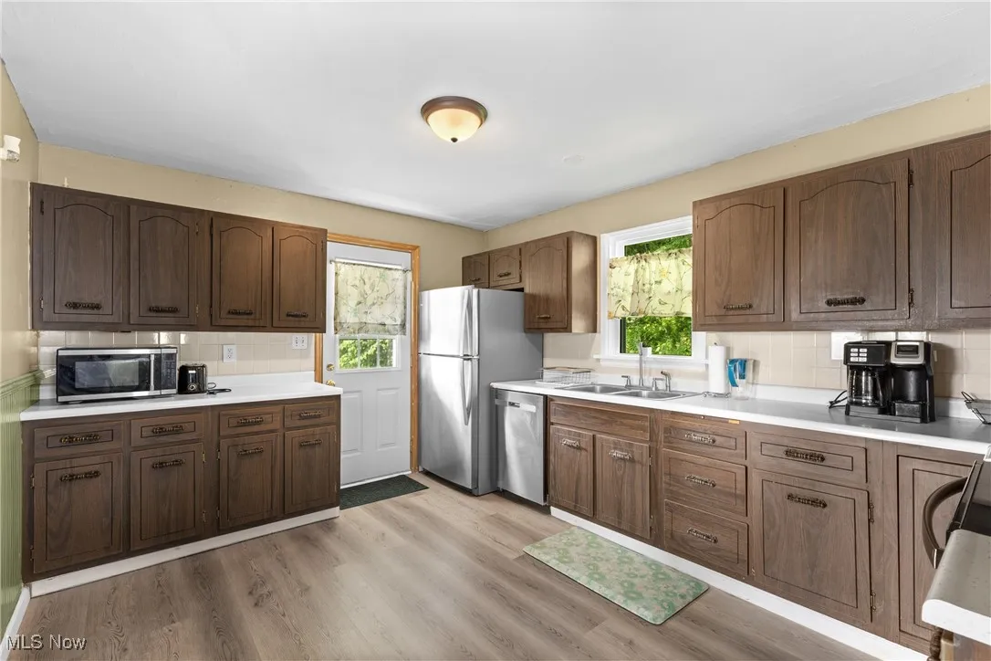 Kitchen featuring appliances with stainless steel finishes, a sink, plenty of natural light, and tasteful backsplash