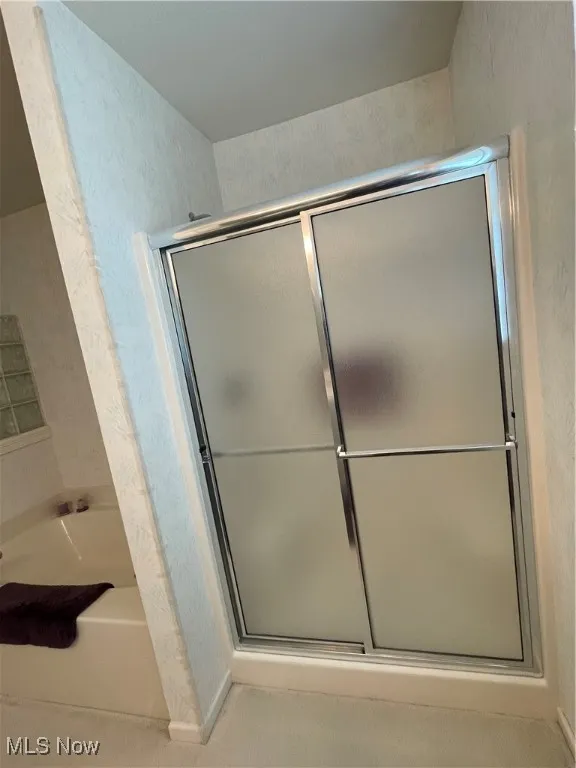 Full bathroom with a garden tub and a stall shower