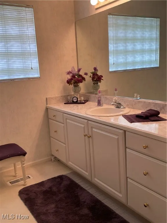 Bathroom with vanity and wallpapered walls