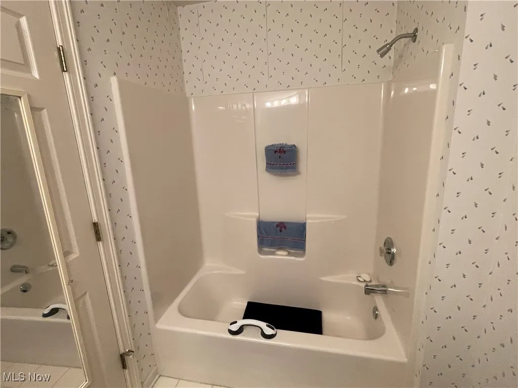 Full bath featuring bathing tub / shower combination and tile patterned floors