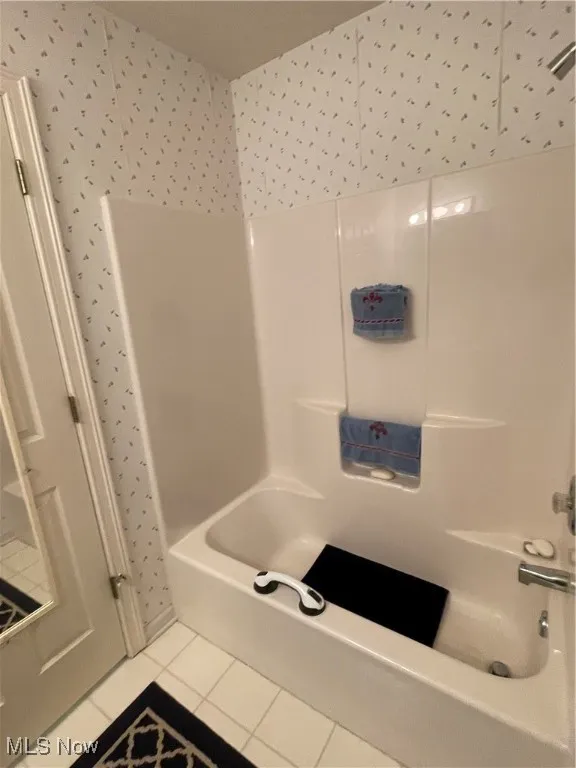 Full bathroom featuring tile patterned floors and bathtub / shower combination