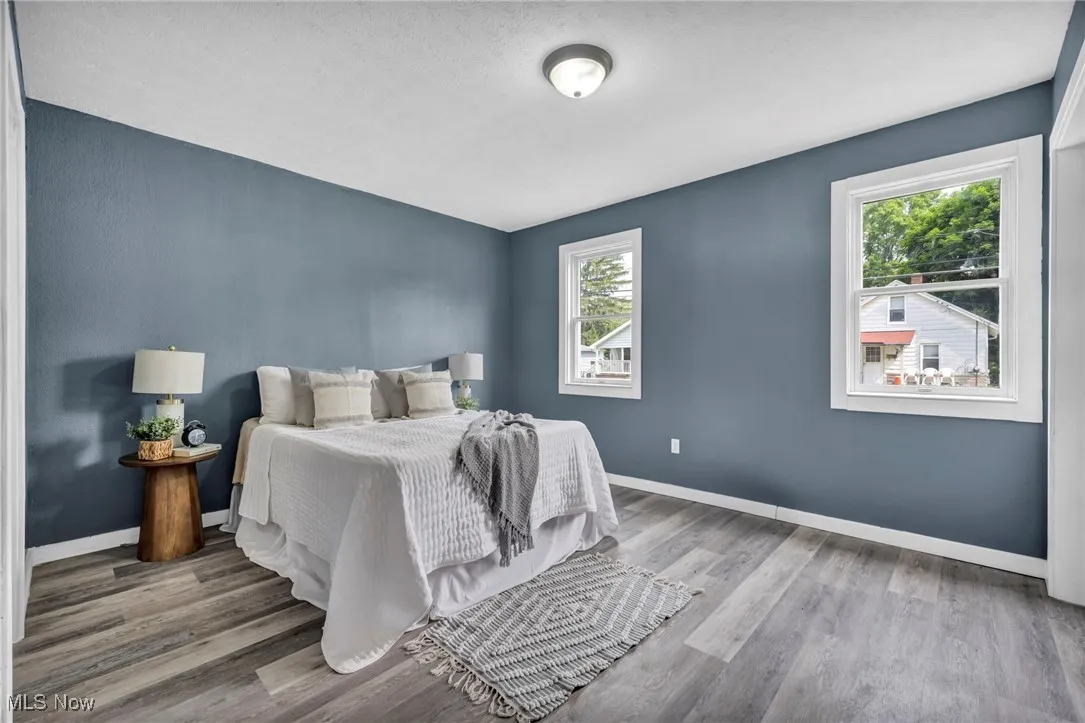 Bedroom with wood finished floors and baseboards