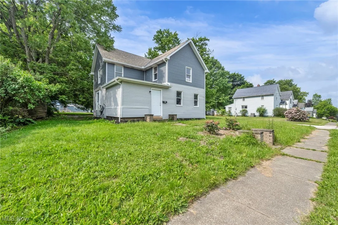 View of side of home featuring a yard