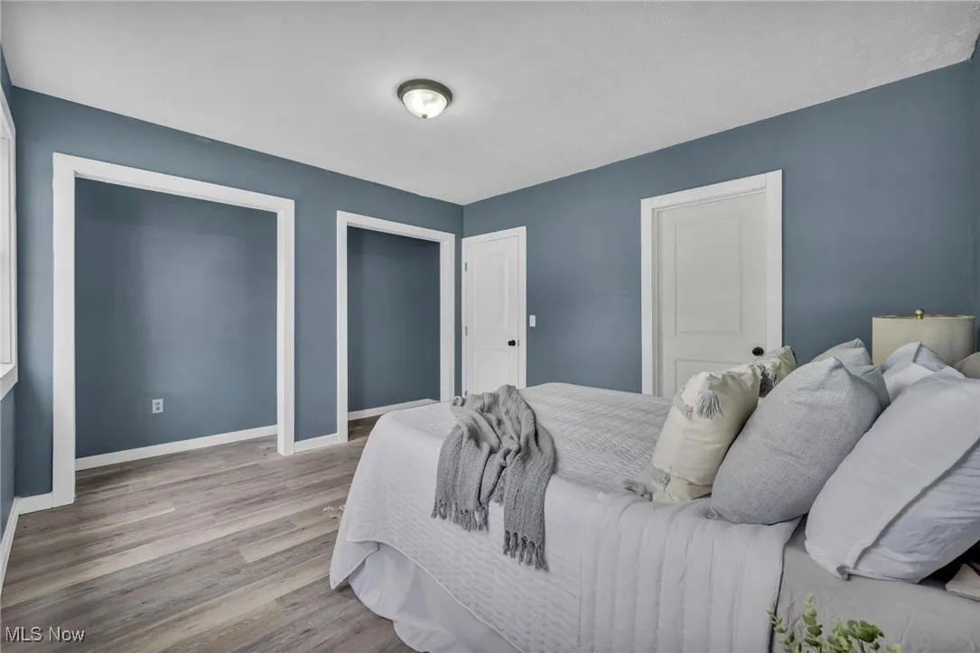 Bedroom with wood finished floors and baseboards