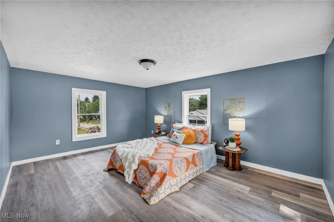 Bedroom featuring wood finished floors, baseboards, and a textured ceiling