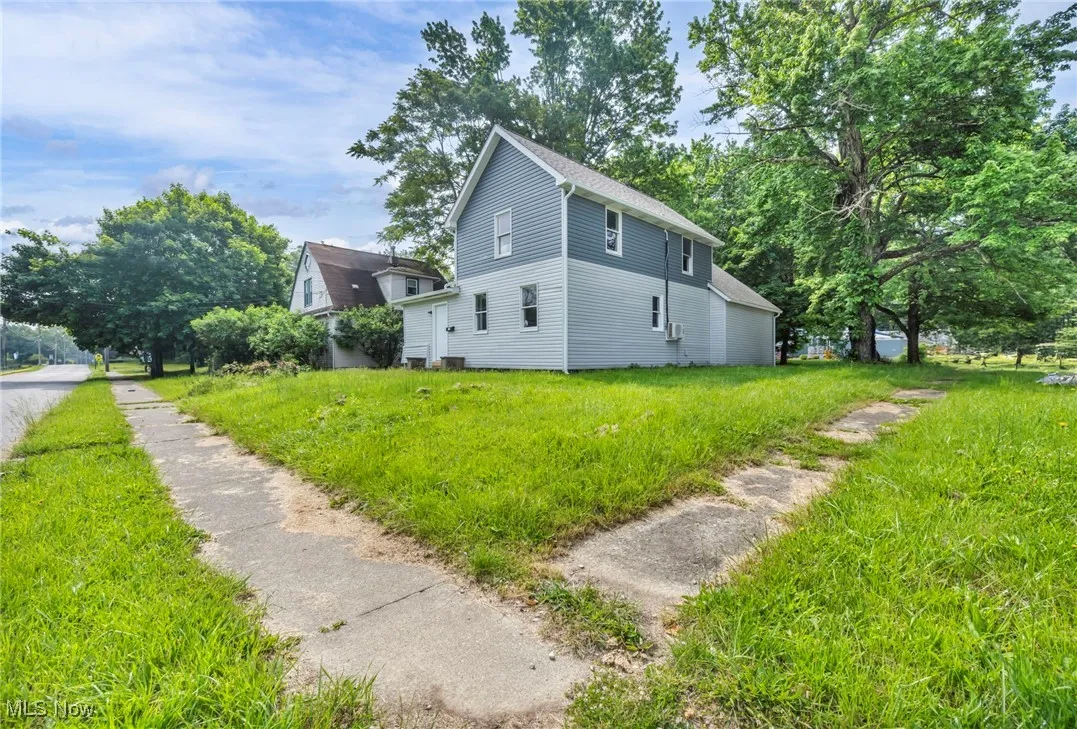 View of home's exterior with roof with shingles and a lawn