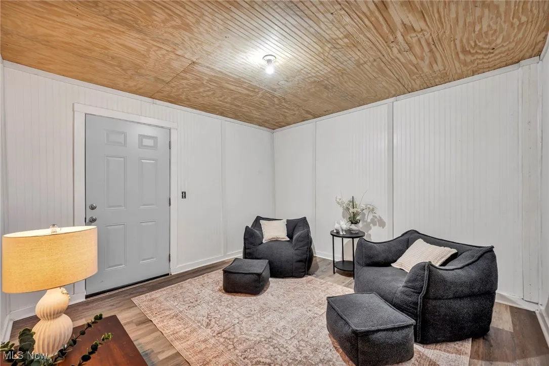 Living area featuring wooden ceiling, wood finished floors, and baseboards