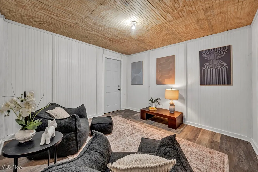 Living area featuring baseboards, wooden ceiling, and wood finished floors