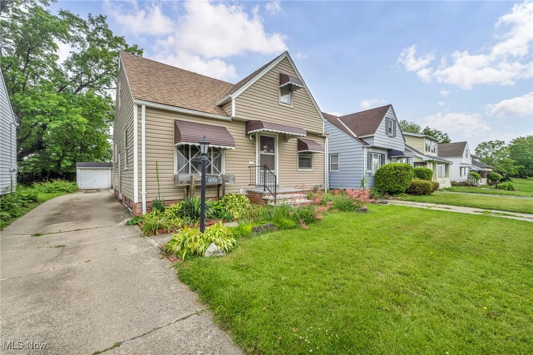 View of front of property featuring a front lawn and a garage