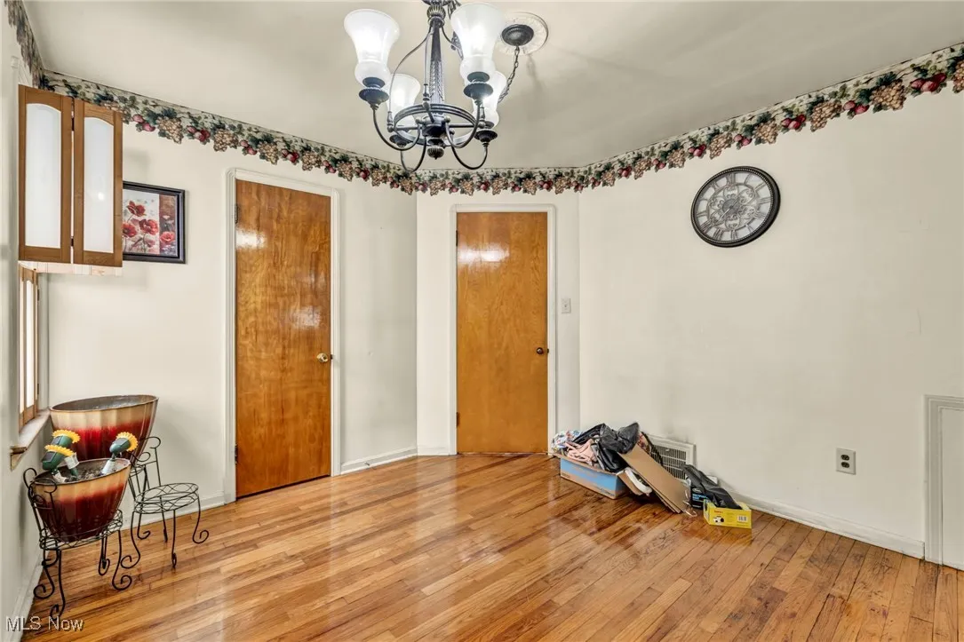 Dining room with light wood finished floors, a chandelier, and baseboards