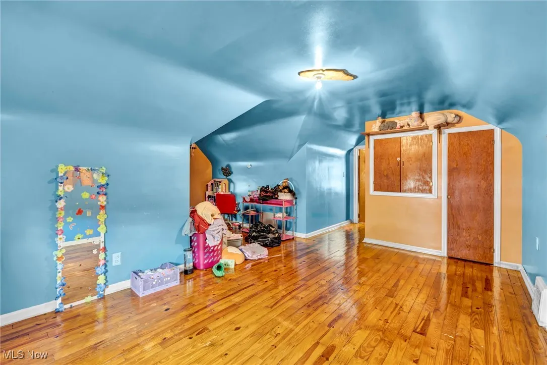 Bonus room featuring wood-type flooring, lofted ceiling, and baseboards