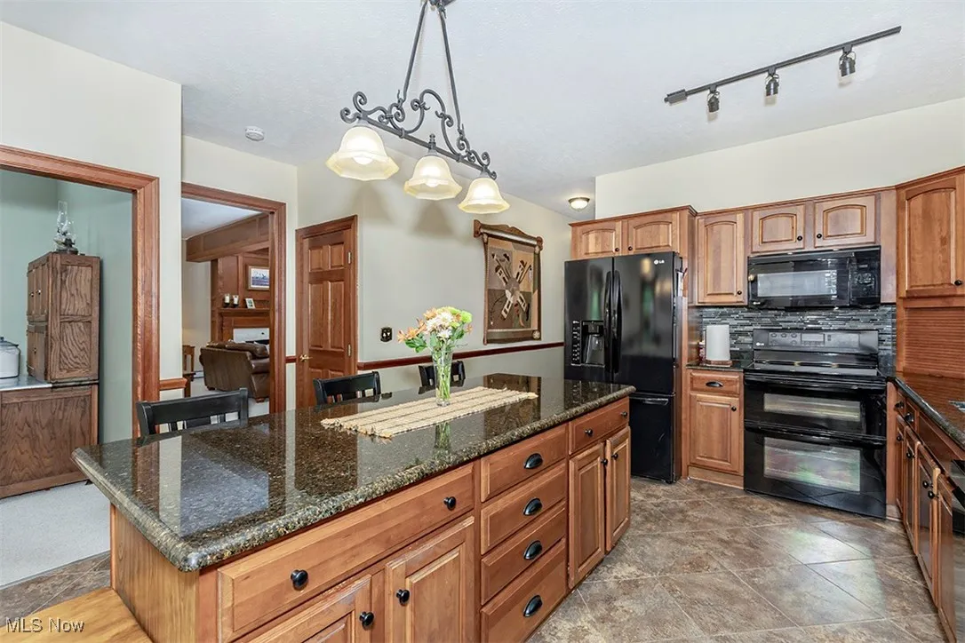 Generous island, granite countertops and tiled flooring. Note the solid natural cherry cabinetry.