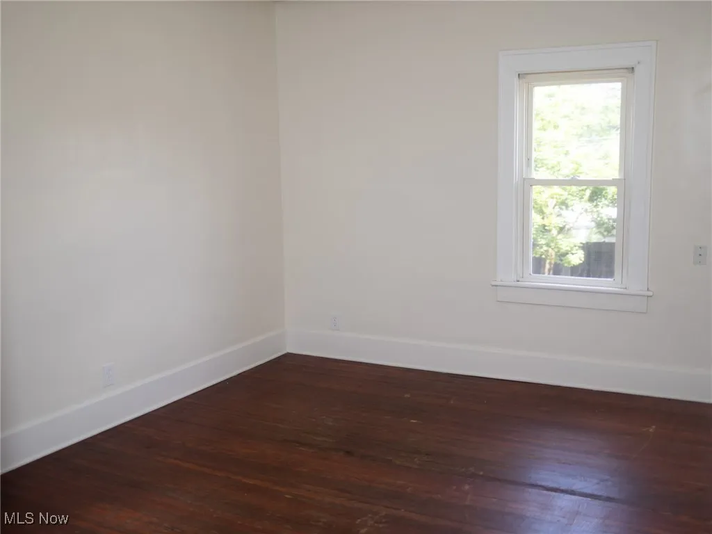 Spare room featuring dark wood finished floors