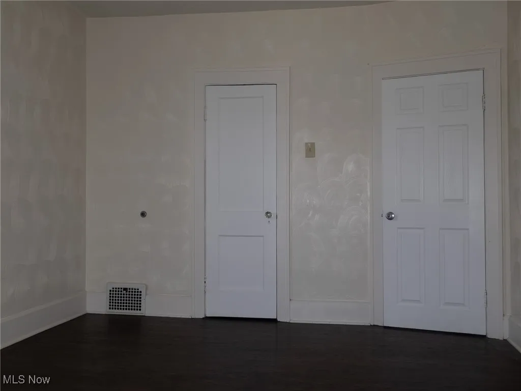 Spare room featuring dark wood-type flooring
