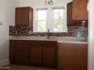 Kitchen with decorative backsplash, light countertops, and brown cabinets