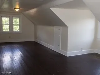 Additional living space with hardwood / wood-style flooring and vaulted ceiling