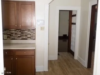 Hall featuring baseboards and dark wood-style floors