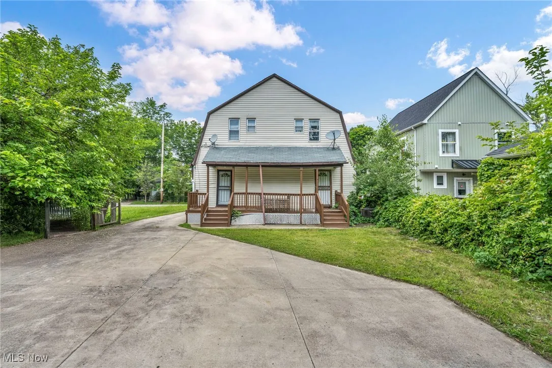 Dutch colonial with covered porch, concrete driveway, a front yard, and a gambrel roof