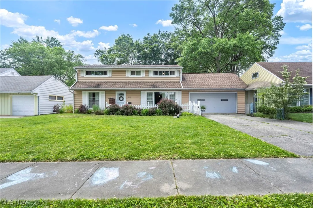 Traditional home with driveway, a front yard, and a garage