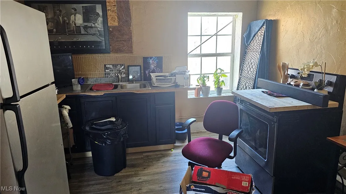 Home office with wood finished floors, a textured wall, and a sink