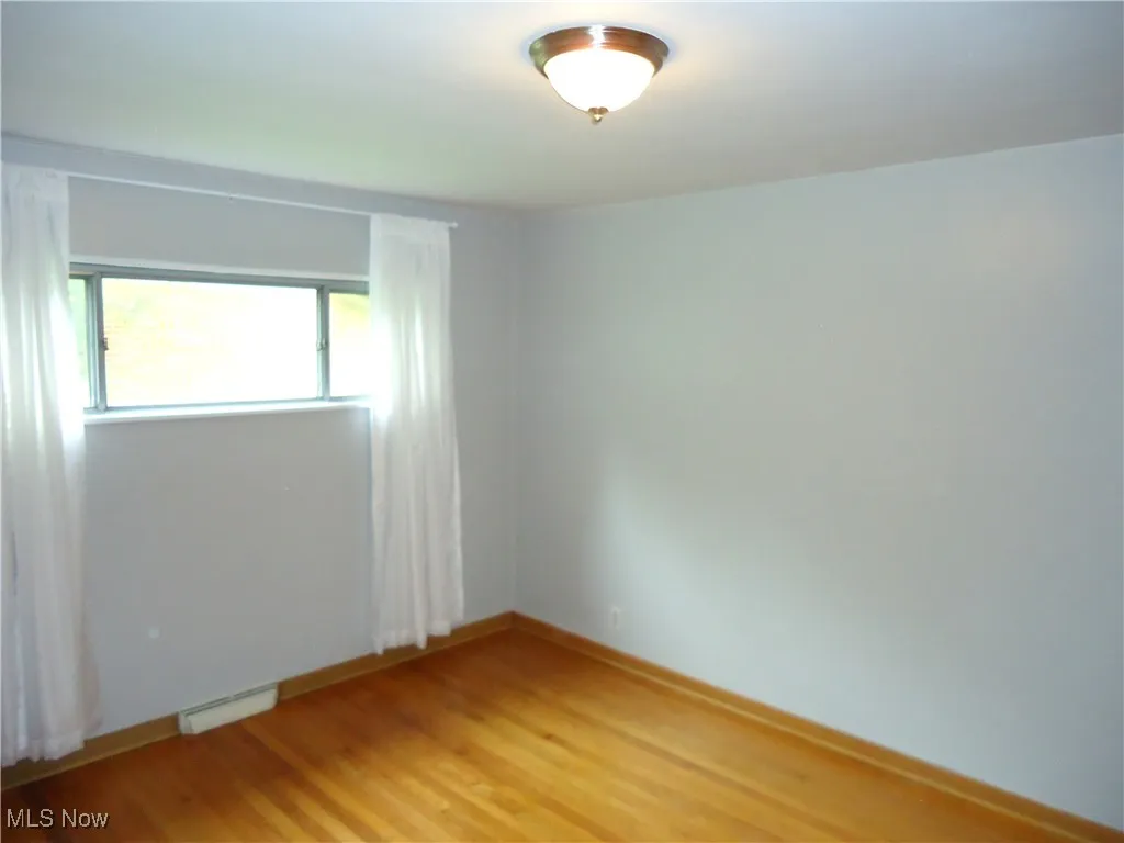 Empty room with light wood finished floors and baseboards