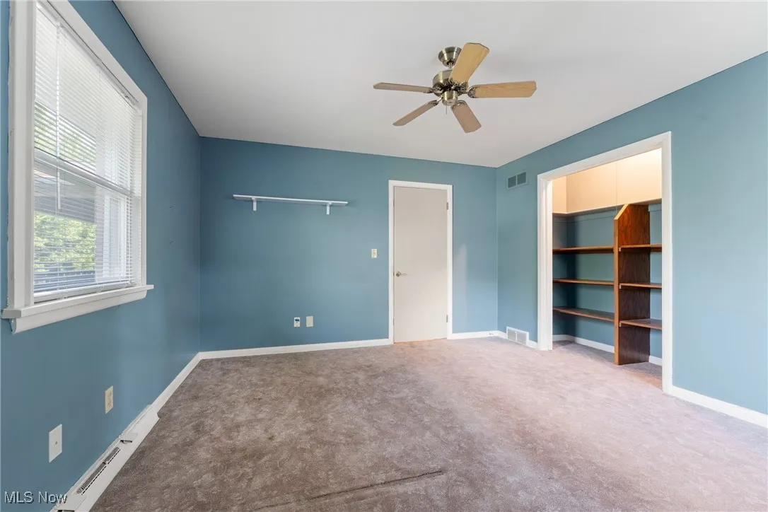 Unfurnished bedroom with carpet flooring and ceiling fan
