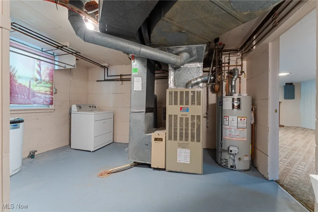 Below grade area featuring washer / dryer, water heater, and electric panel