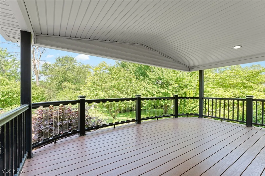 Wooden terrace featuring view of wooded area