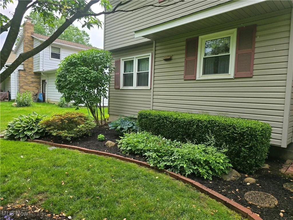 View of rear of property featuring lucious land