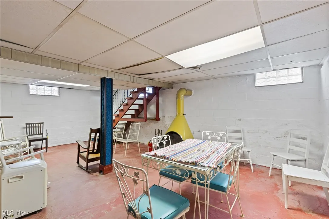 Below grade area featuring a paneled ceiling and stairs