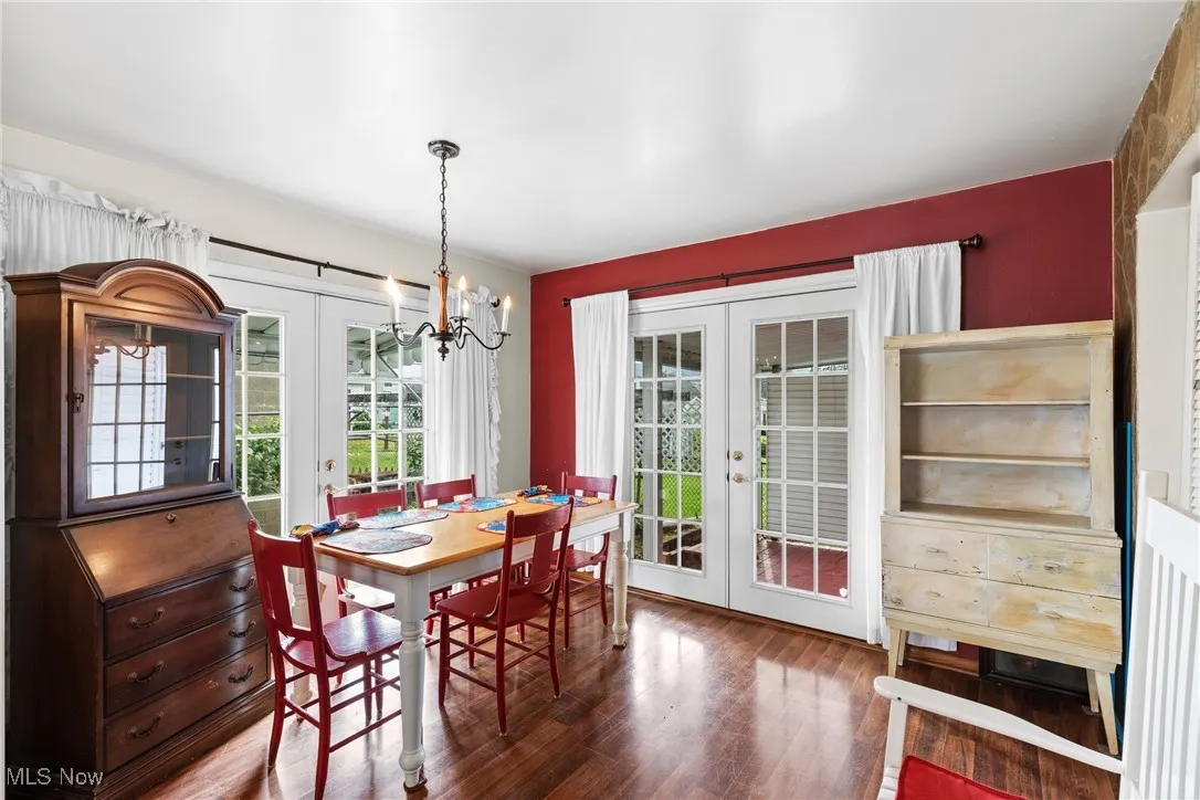 Dining room with french doors, a chandelier, and wood finished floors