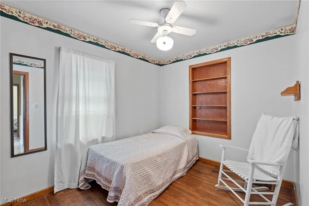 Bedroom with baseboards, wood finished floors, and ceiling fan