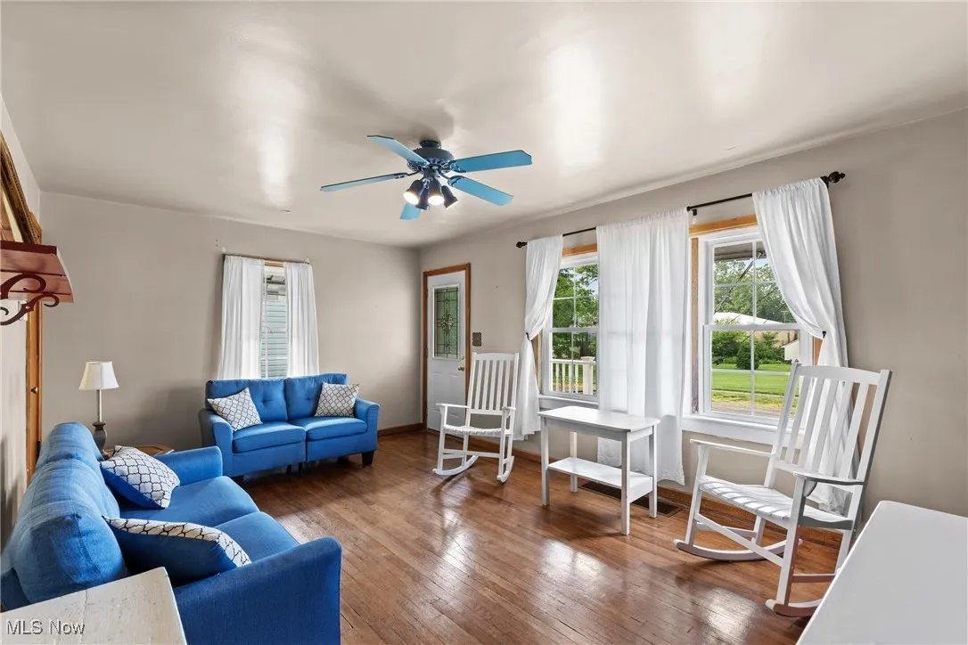 Living room featuring wood-type flooring and ceiling fan