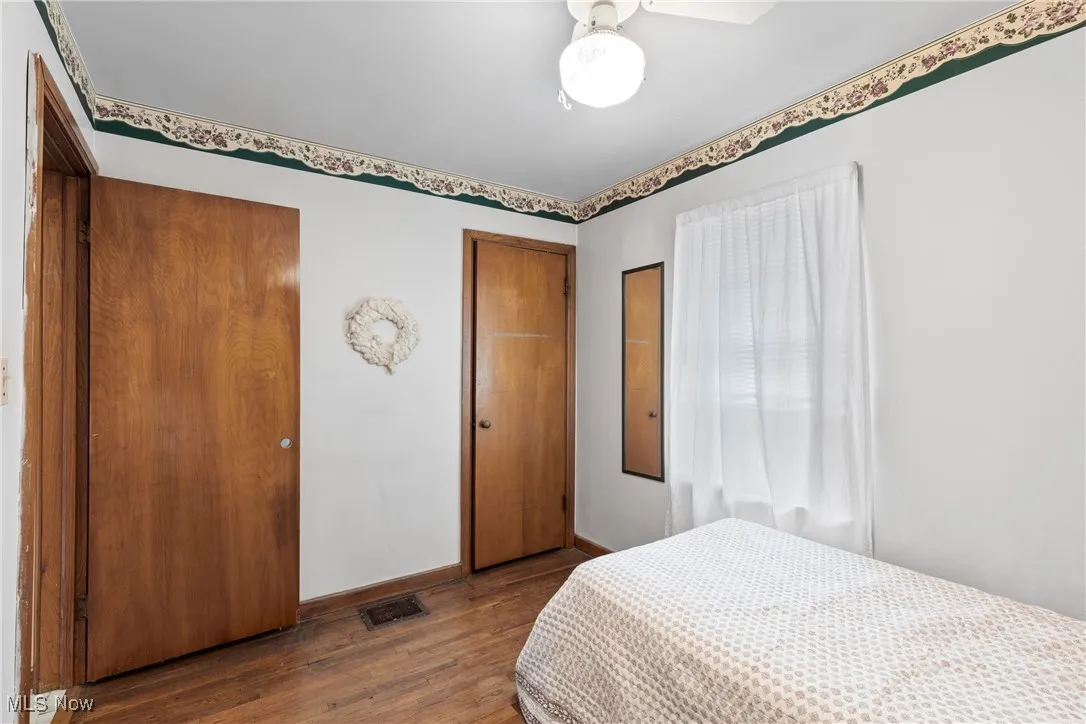 Bedroom featuring wood finished floors and baseboards