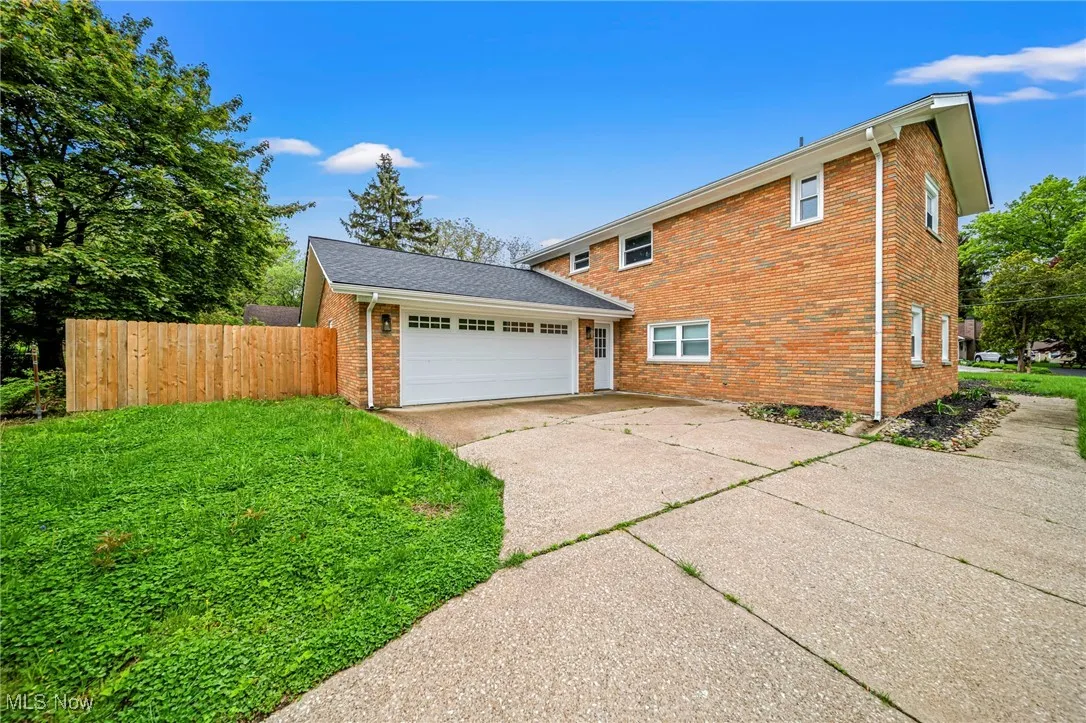 View of side of home with brick siding and a garage