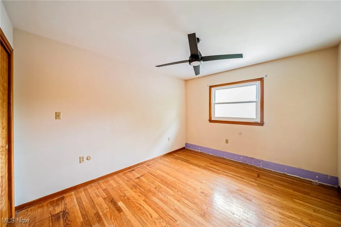 Unfurnished room with baseboards, wood finished floors, and ceiling fan