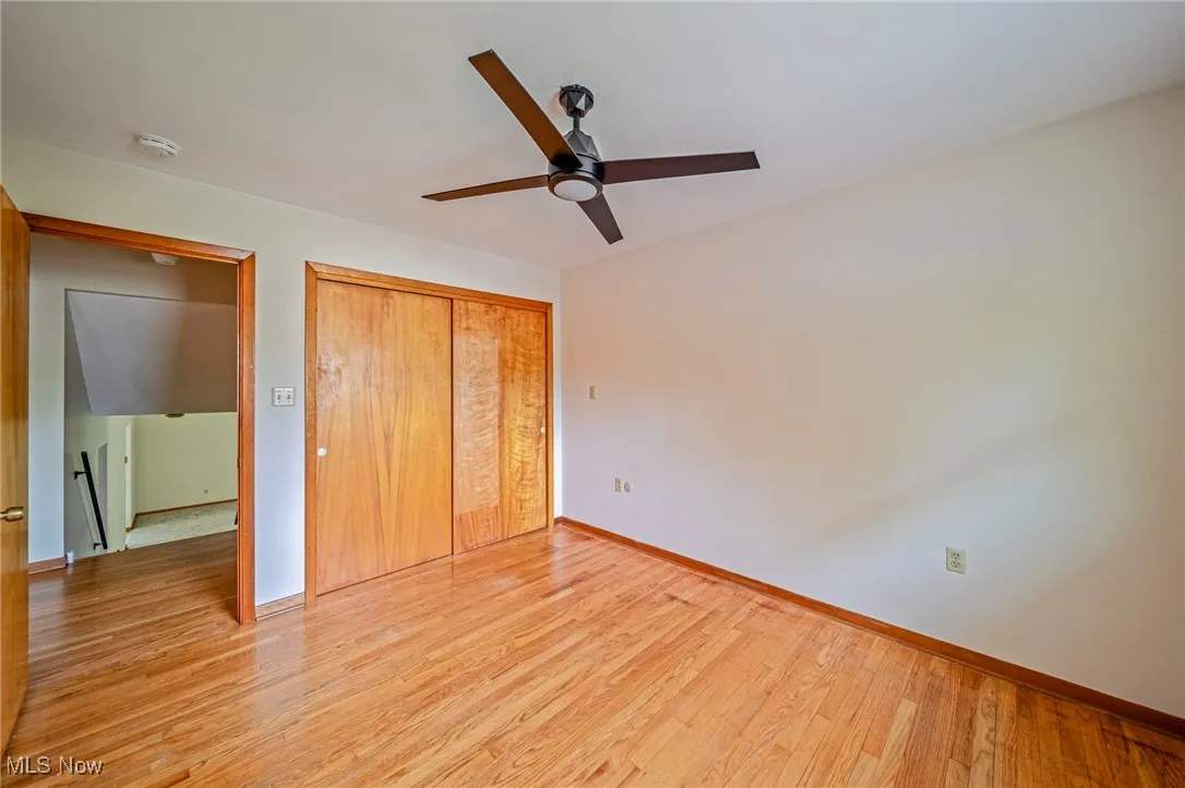 Unfurnished bedroom featuring baseboards, light wood finished floors, a closet, and a ceiling fan