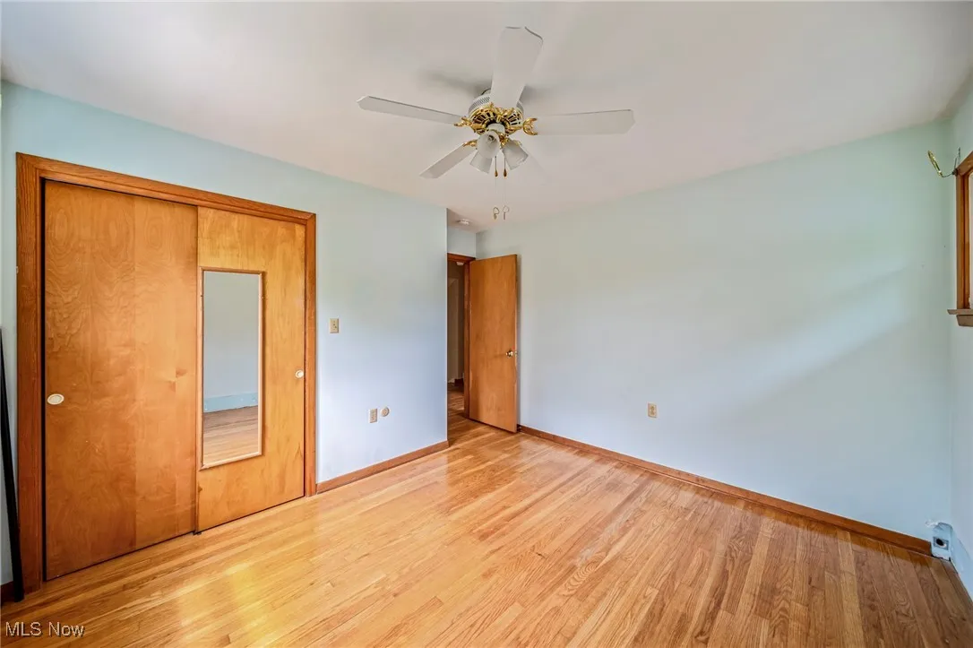 Unfurnished bedroom with light wood-type flooring, baseboards, and a ceiling fan