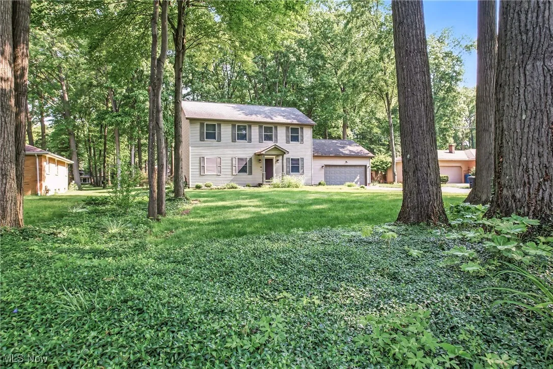 Colonial home with a front yard and an attached garage